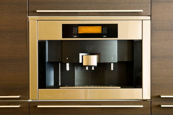 stainless steel espresso machine mounted on kitchen wall