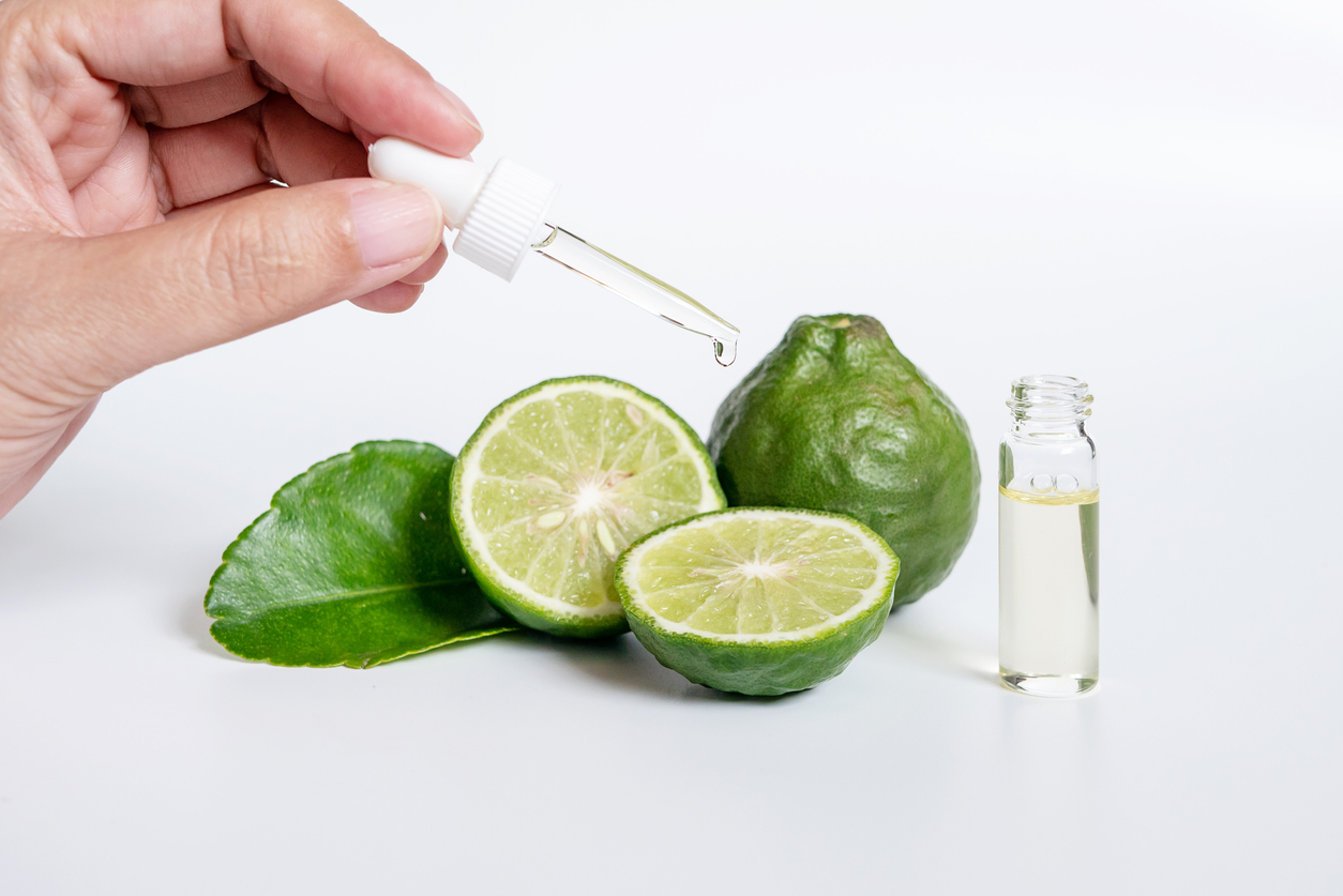 bergamot fruits next to a vial of essential oil