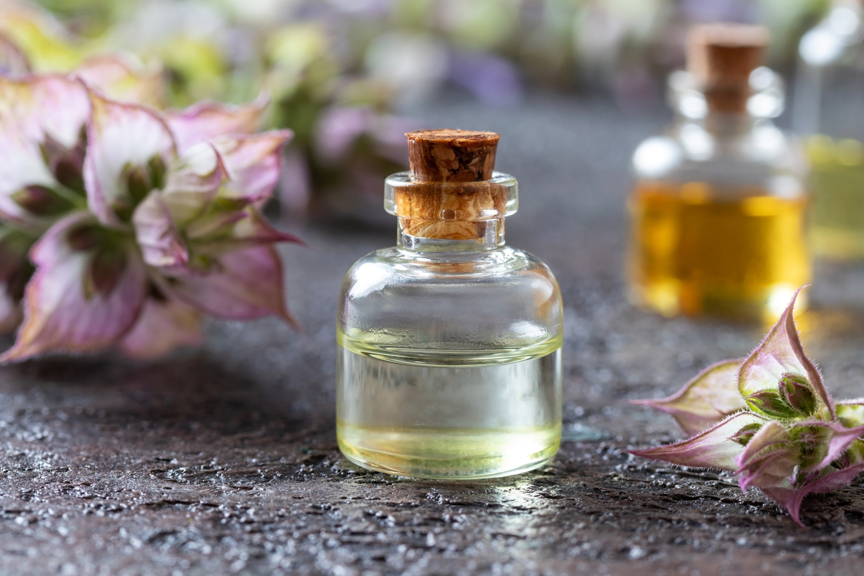 vial of essential oil against picked clary sage