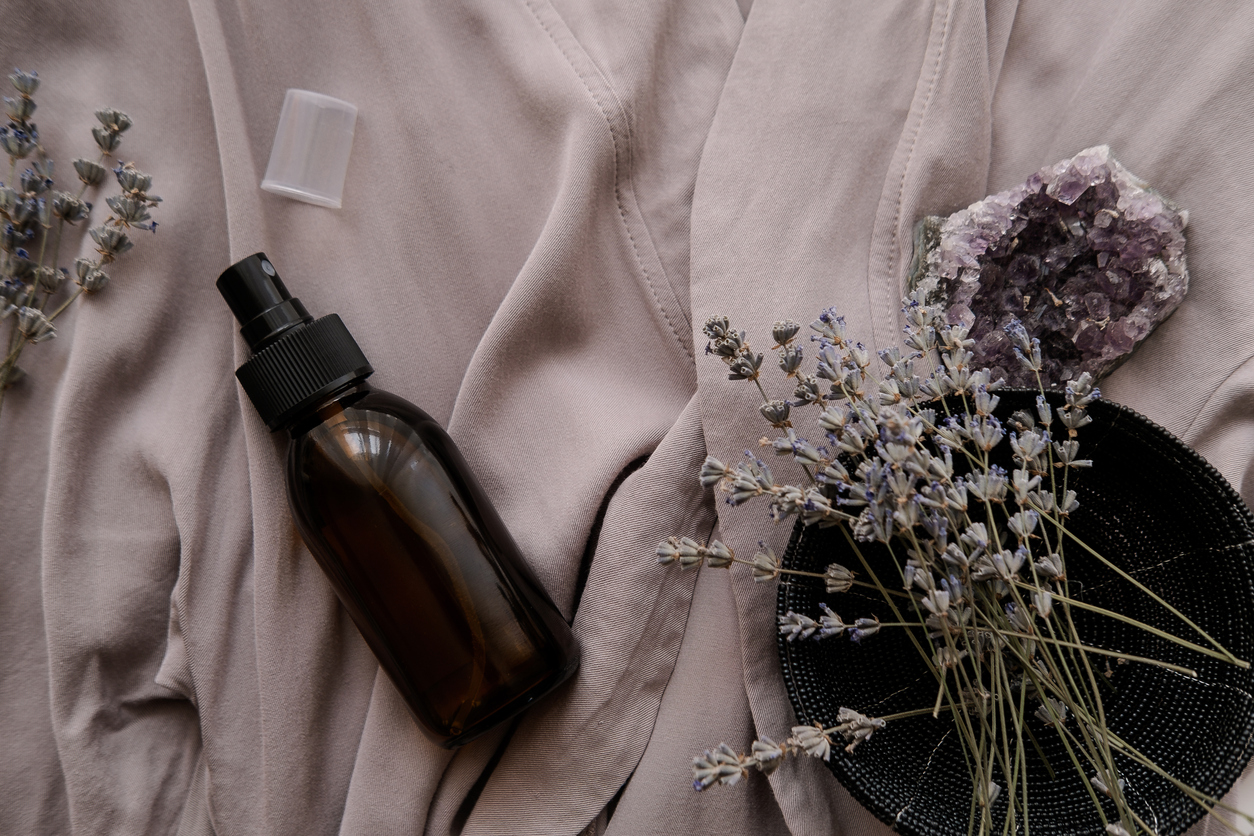lavender essential oil spray bottle against gray linen