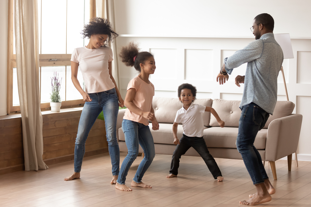 family of four dancing in the living room