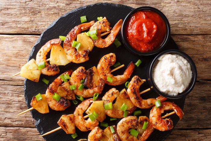 grilled pineapple-shrimp skewers served on a plate