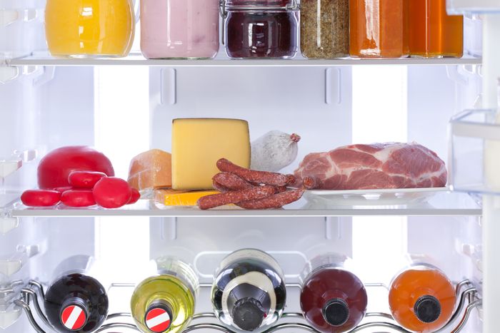 Meat and cheese organized inside a refrigerator