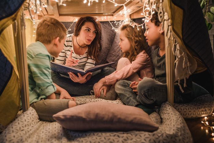 happy mother reading to children an indoor tent