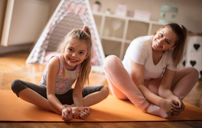 mother and young daughter stretching together before exercising