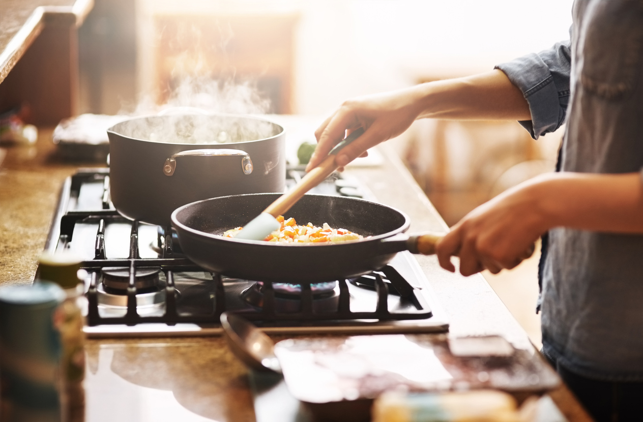 closeup of cast iron cooktop as a woman prepares a meal