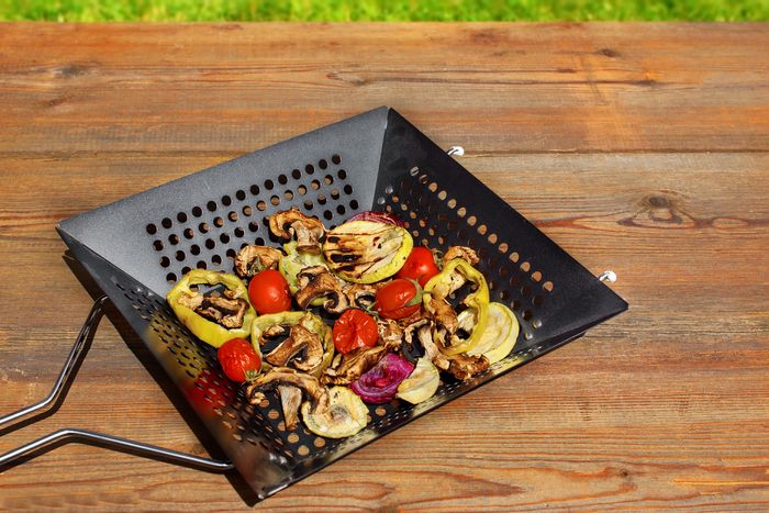 grilled vegetables mix in a cast iron basket on wood table