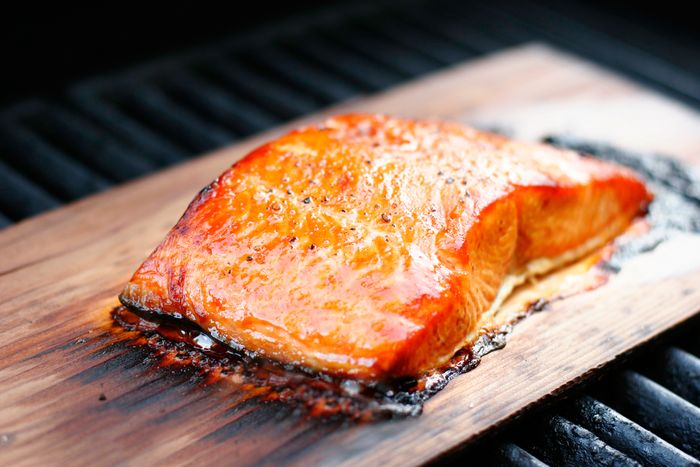 Salmon fillet with coarse ground pepper, grilled over a cedar plank