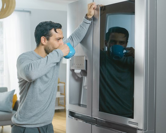 Man prepares to knock on his fridge screen to see inside contents