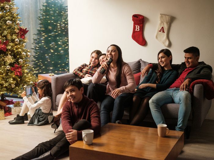 family squishes together on the couch during a holiday celebration