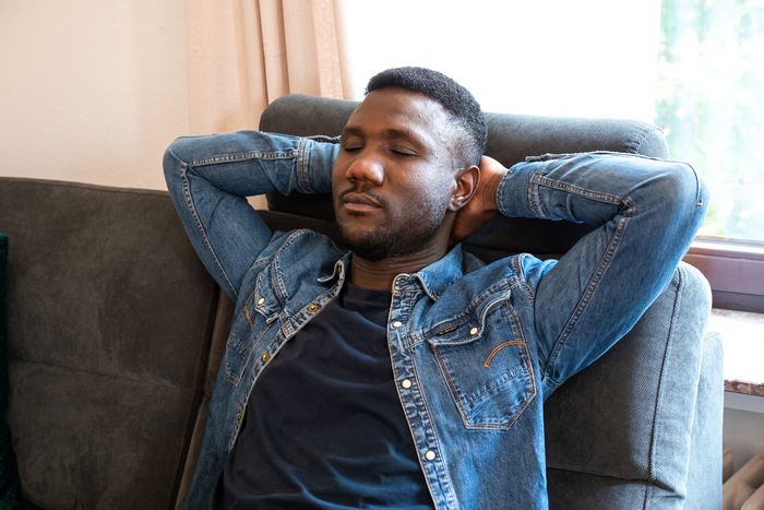Man snoozes sitting up in a recliner