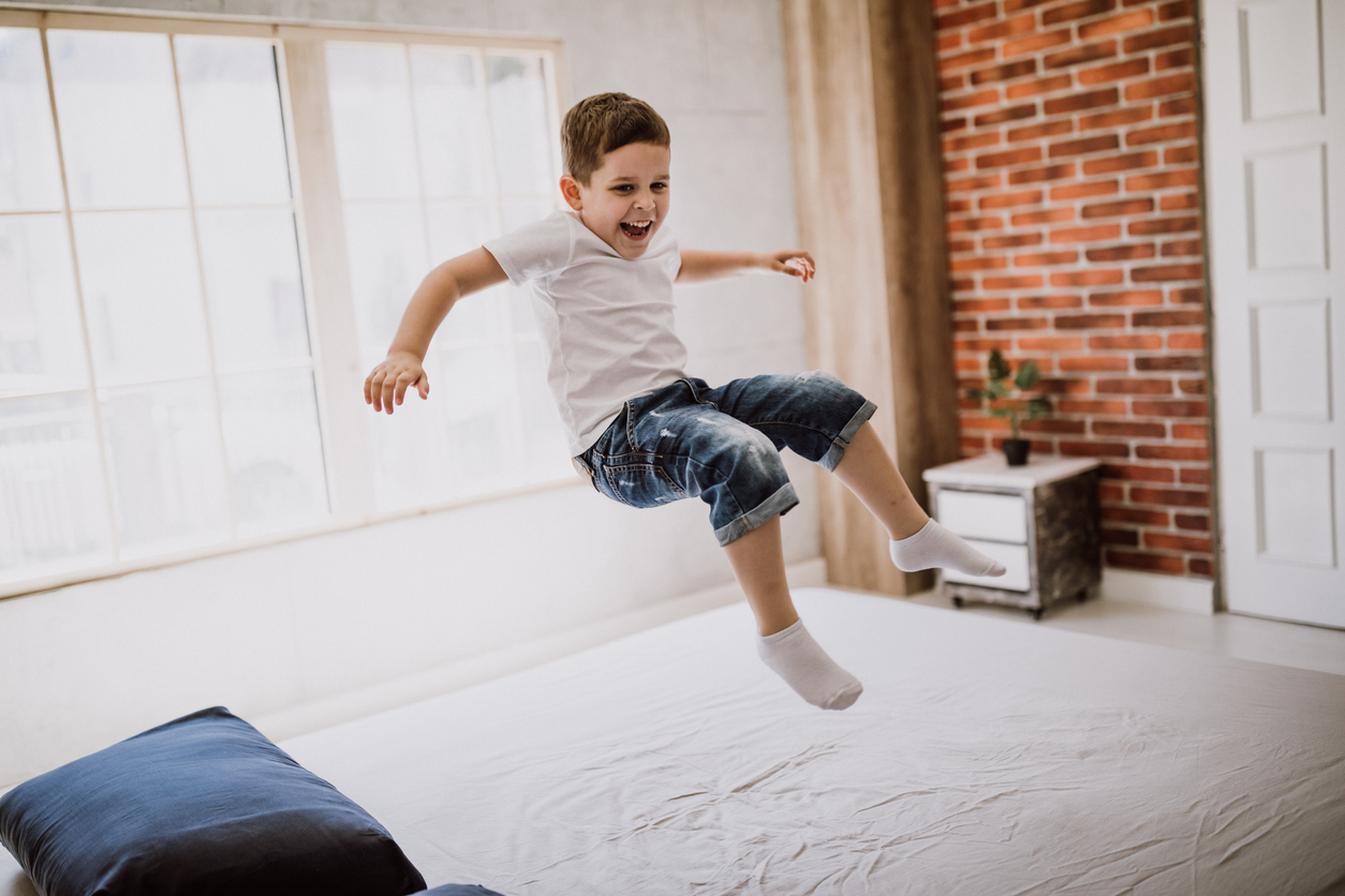 boy jumping on mattress