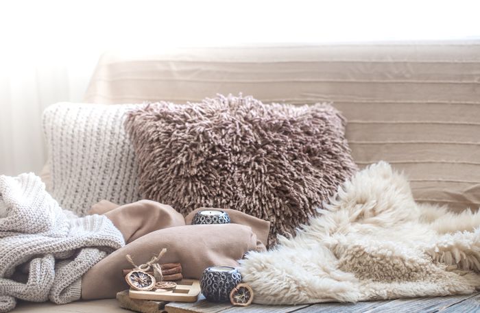 A pile of neutral-colored pillows and blankets 