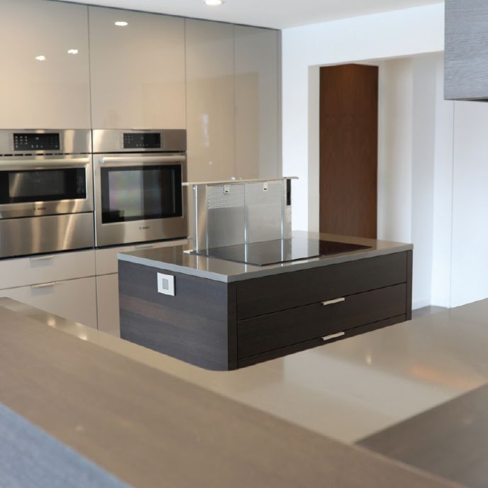 Kitchen island with Bosch downdraft and wall oven in the background.