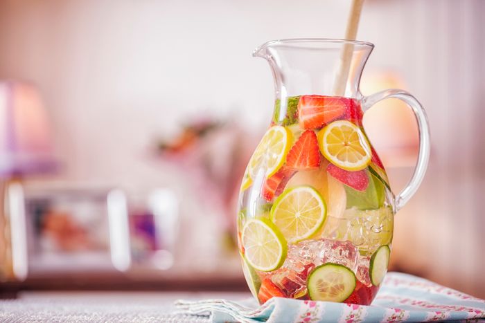 A pitcher full of water and fruit slices.