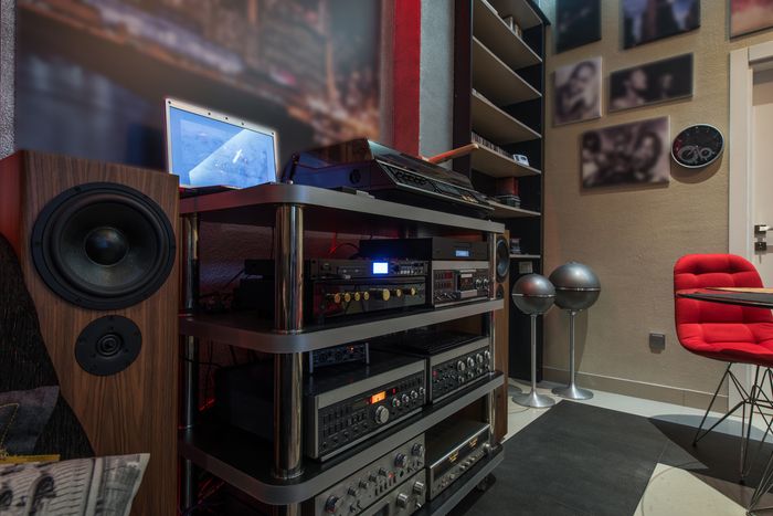 A shelf full of audio equipment with large speakers on either side