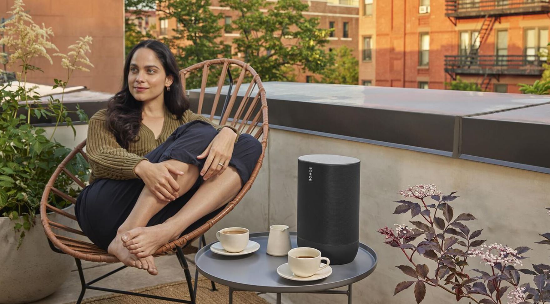 girl sitting outside next to small table with speaker on it