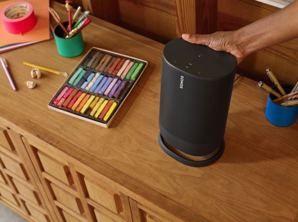 mobile sonos move speaker being picked up next to art supplies