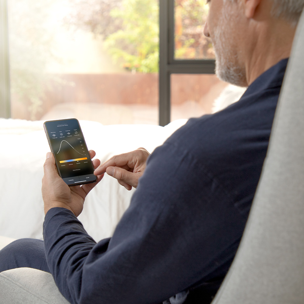 Man holding smart phone looking at lighting graph