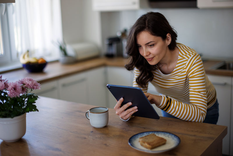 Smiling woman using a tablet to shop online
