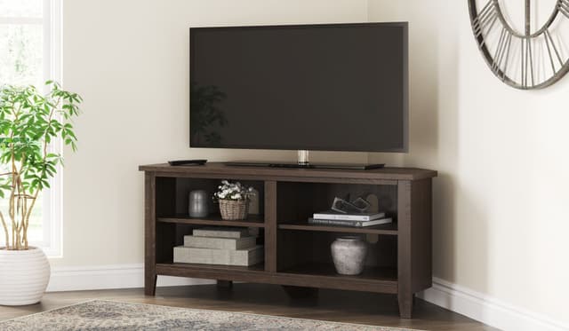 The Signature Design by Ashley Camiburg collection corner TV stand with decor 
