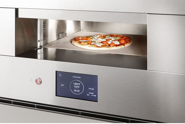 A pizza cooking inside a Monogram 30” electric hearth oven 