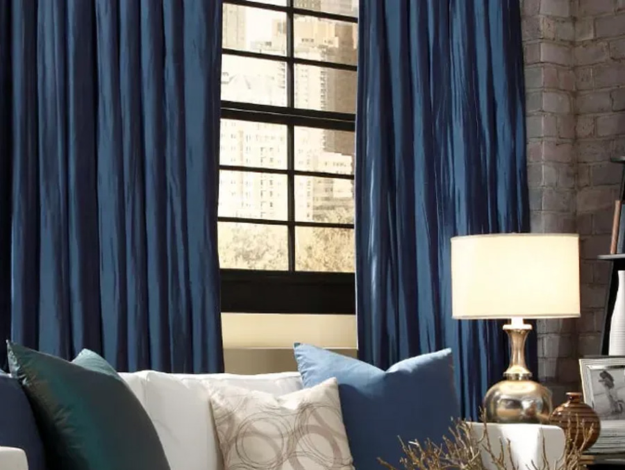 Long blue fabric drapes in a living room