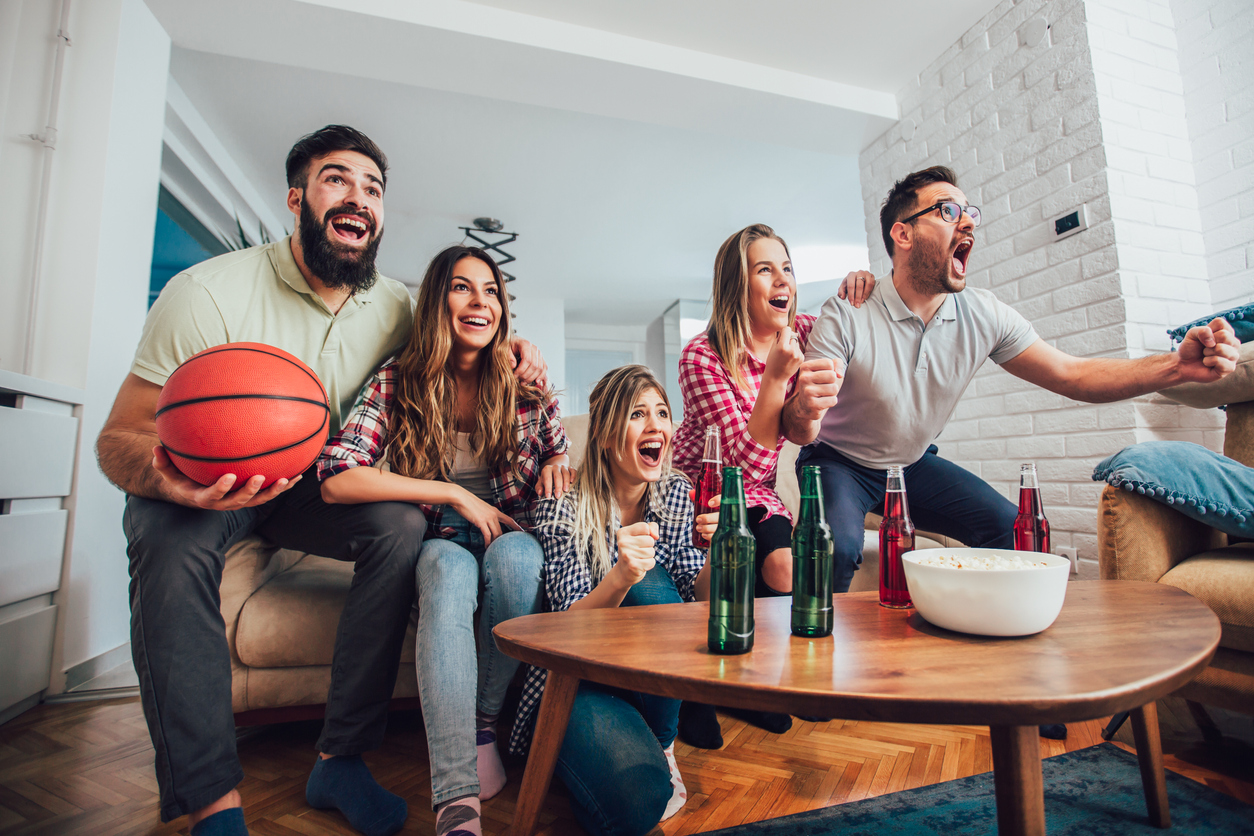 people on couch are excited watching TV