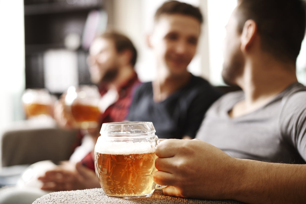 someone holding a glass mug of beer