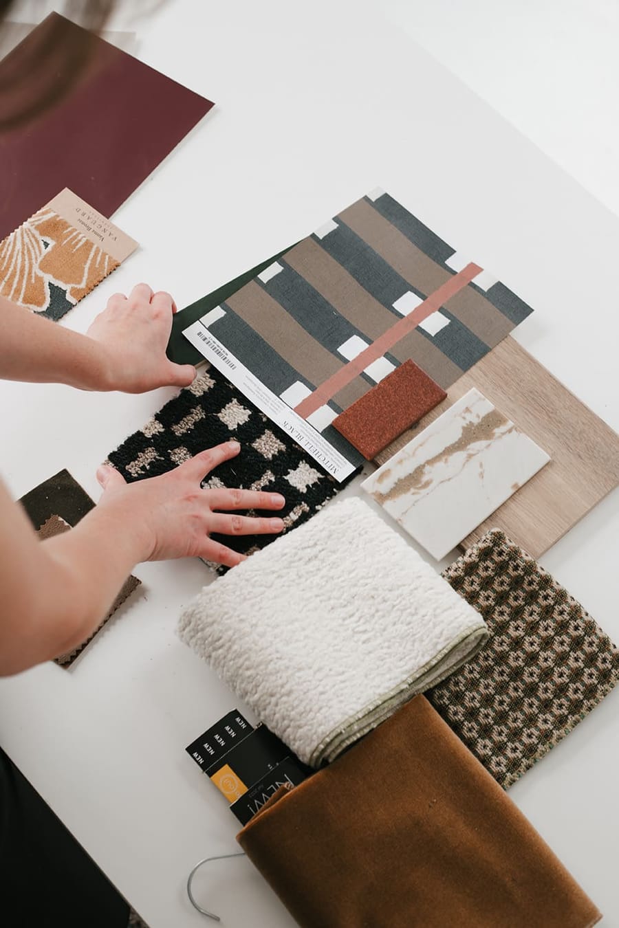 Designer arranging fabric, tile and wood samples for a design consultation