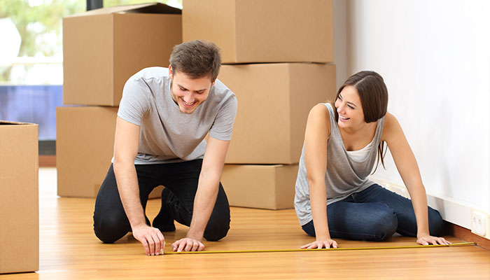 Man and woman measuring as they move into a new place