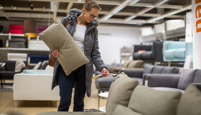 Woman shopping for furniture and looking at the pricing