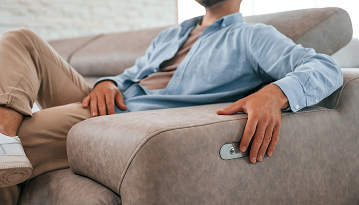 Man sitting on sofa with power buttons on side