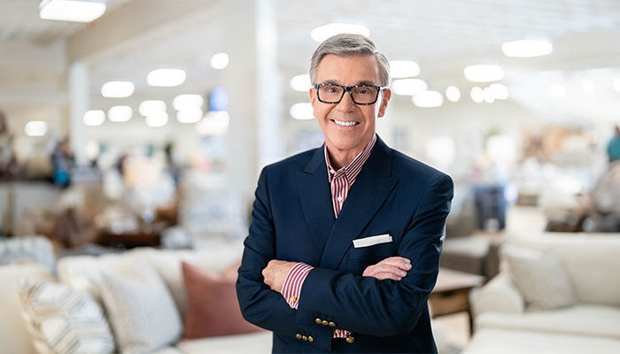 Bob Mills standing with his arms crossed in a showroom