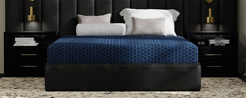 Blue Ice Renew mattress in a dark furnished, modern styled bedroom.