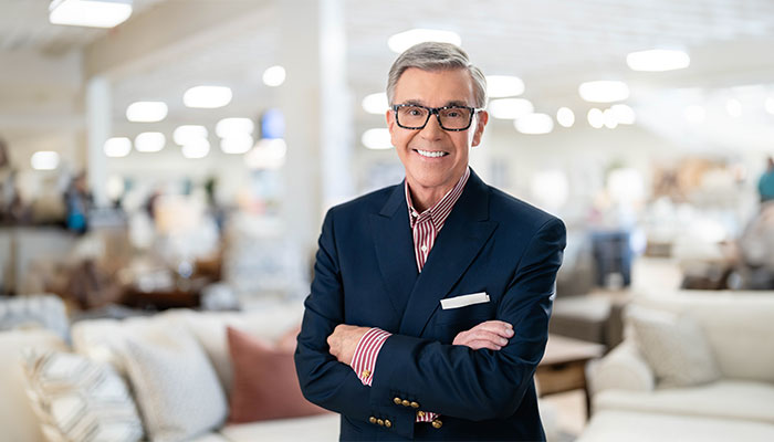 Bob Mills with his arms crossed in a showroom