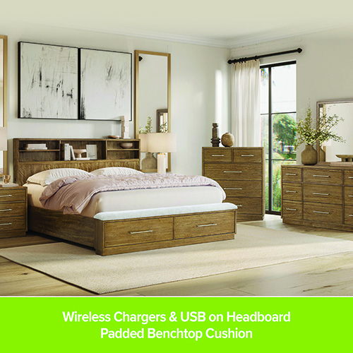 Bedroom furniture set in a warm wood finish featuring a bed with storage drawers, matching nightstands, a dresser, and a chest. The room includes neutral bedding, table lamps, wall art, and large windows letting in natural light. Darvin Furniture & Mattress branding promotes the bedroom collection.