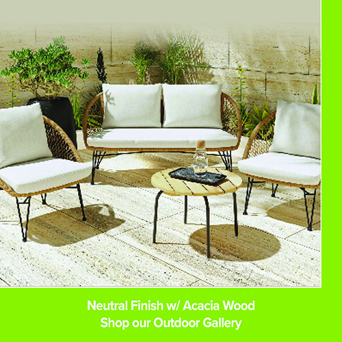 Outdoor seating set with a woven loveseat and two matching chairs with white cushions arranged around a small round table on a patio. Potted plants and a wood wall backdrop create a relaxed outdoor setting. Text reads “Neutral Finish w/ Acacia Wood. Shop our Outdoor Gallery.”