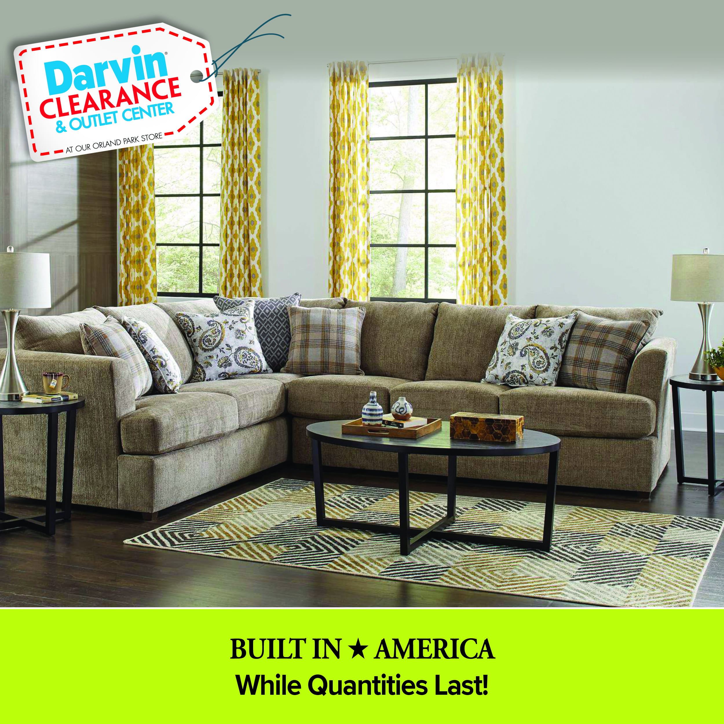 A living room scene featuring a large tan sectional sofa adorned with plaid and paisley pillows. The room includes a black oval coffee table, matching end tables with lamps, a geometric patterned rug, and yellow patterned curtains. A 'Darvin Clearance & Outlet Center' price tag is in the top left corner, and a lime green footer reads 'BUILT IN ★ AMERICA' and 'While Quantities Last!'.