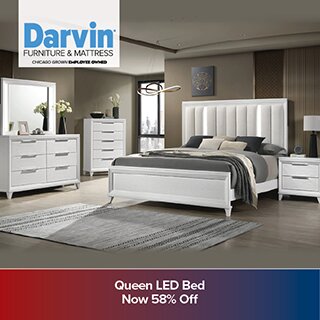 A promotional advertisement for Darvin Furniture & Mattress showcasing a modern white bedroom set with a Queen LED Bed, dresser with mirror, chest, and nightstand. The bed features a tall, vertically paneled headboard with integrated lighting. The banner at the bottom reads 'Queen LED Bed Now 58% Off'.'