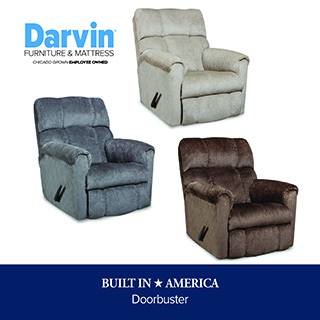 A promotional advertisement graphic for a doorbuster recliner sale at Darvin Furniture & Mattress. The image showcases three plush fabric reclining armchairs with prominent reclining handles on their sides, arranged against a solid white background. The recliners are featured in three different colors: a light beige or cream version at the top, a slate blue or grey version on the left, and a dark chocolate brown version on the right. The light blue and black Darvin Furniture & Mattress logo appears in the upper left corner. A solid dark blue banner runs along the bottom of the graphic, featuring white text that reads 'BUILT IN ★ AMERICA' stacked above 'Doorbuster' in a smaller font.