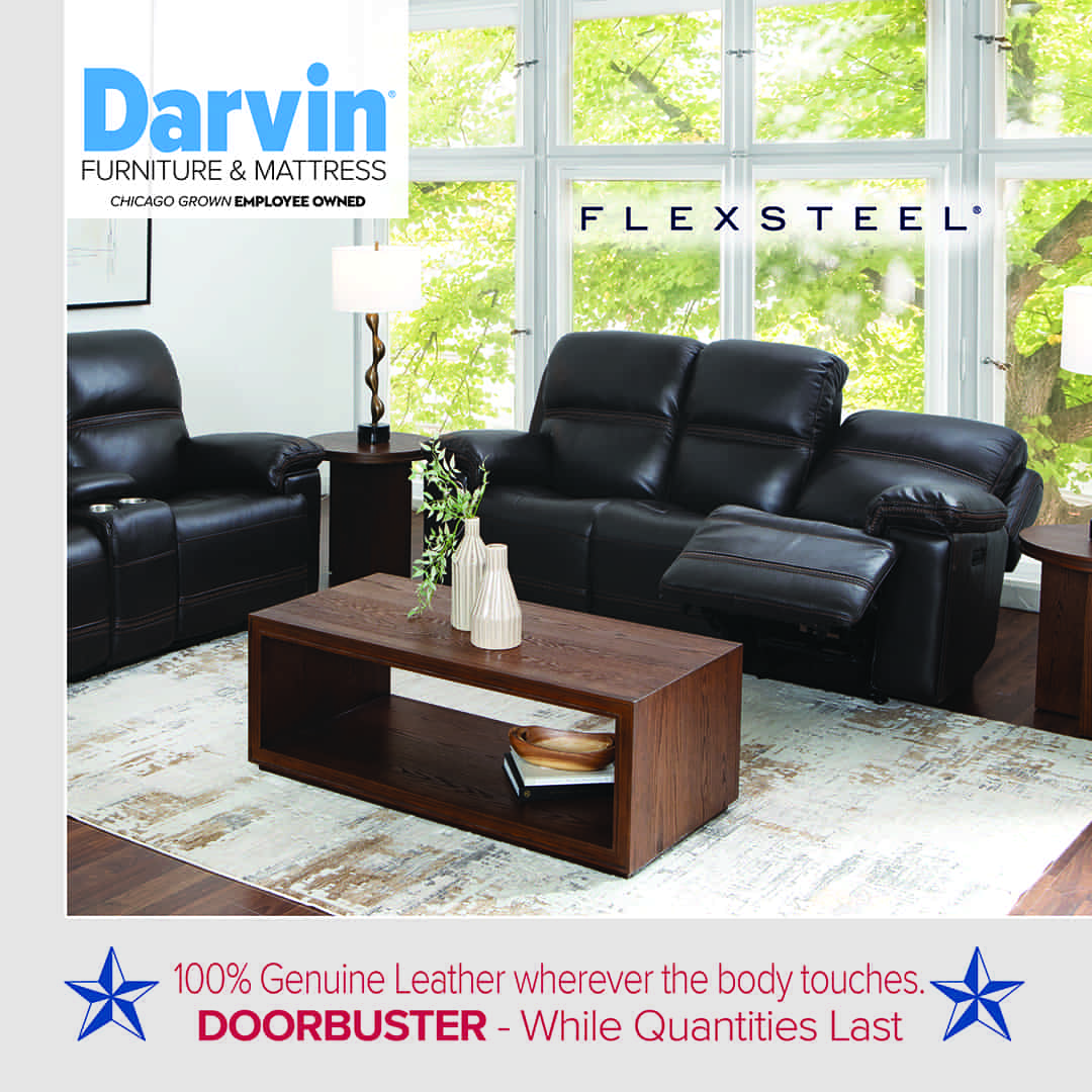 Modern living room featuring a black leather reclining sofa and matching armchair from Flexsteel, accented with wooden side tables and a rectangular coffee table holding decorative vases. The space is bright with large windows showcasing greenery outside. Text on the image reads: “Darvin Furniture & Mattress – Chicago Grown Employee Owned,” “Flexsteel,” and “100% Genuine Leather wherever the body touches. DOORBUSTER – While Quantities Last,” with blue stars on each side.