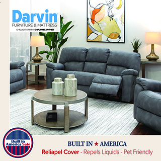 Gray reclining sofa in a styled living room with matching seating, coffee table, and modern décor, shown as a coordinated living room set