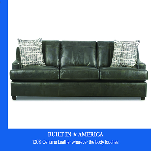 Promotional image from Darvin Furniture & Mattress showing a black leather sofa with two patterned accent pillows on a white background. A blue banner at the bottom reads “Built in America — 100% Genuine Leather wherever the body touches.”