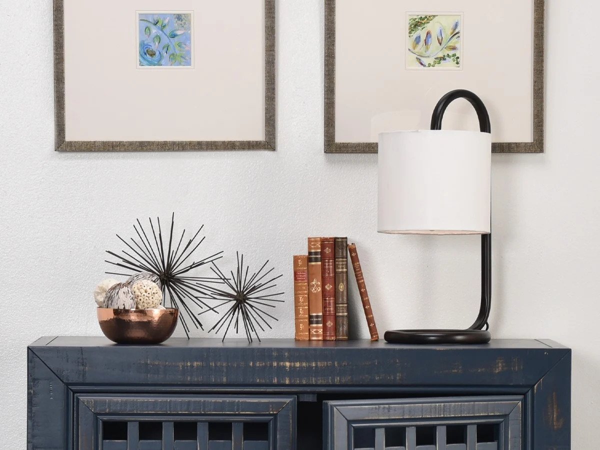 Black console table with decor and wall art