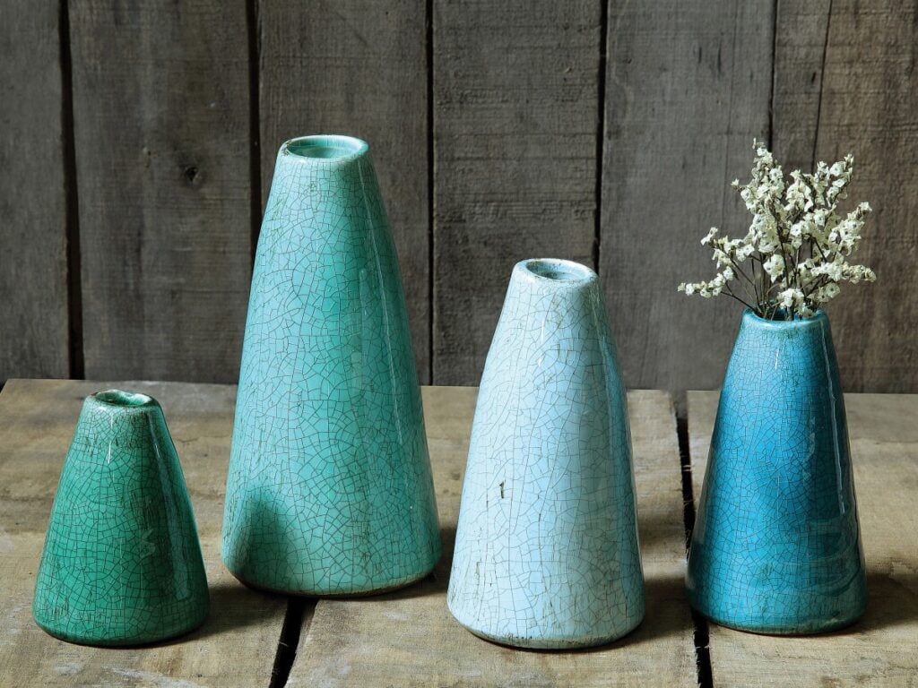 Turquoise ceramic vases on wood shelf