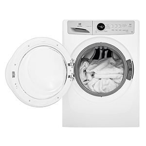 Open Electrolux front load washer full of white towels