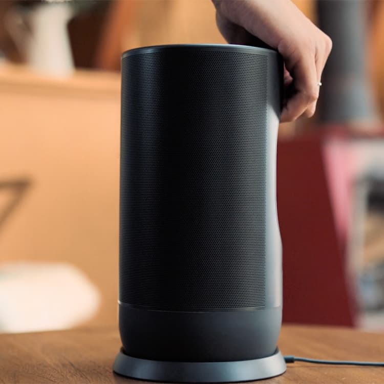 Woman grabbing a Sonos wireless speaker