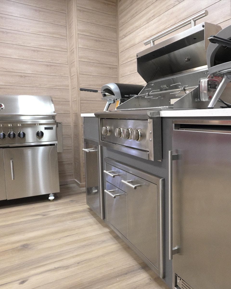 Front view of a casual outdoor kitchen area with stainless steel outdoor appliances.