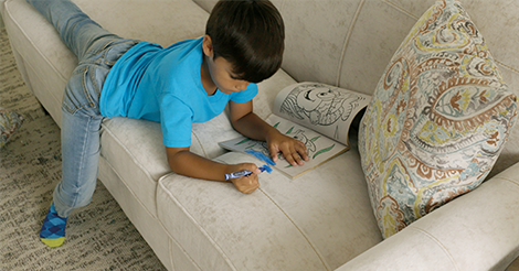 Boy coloring on a couch